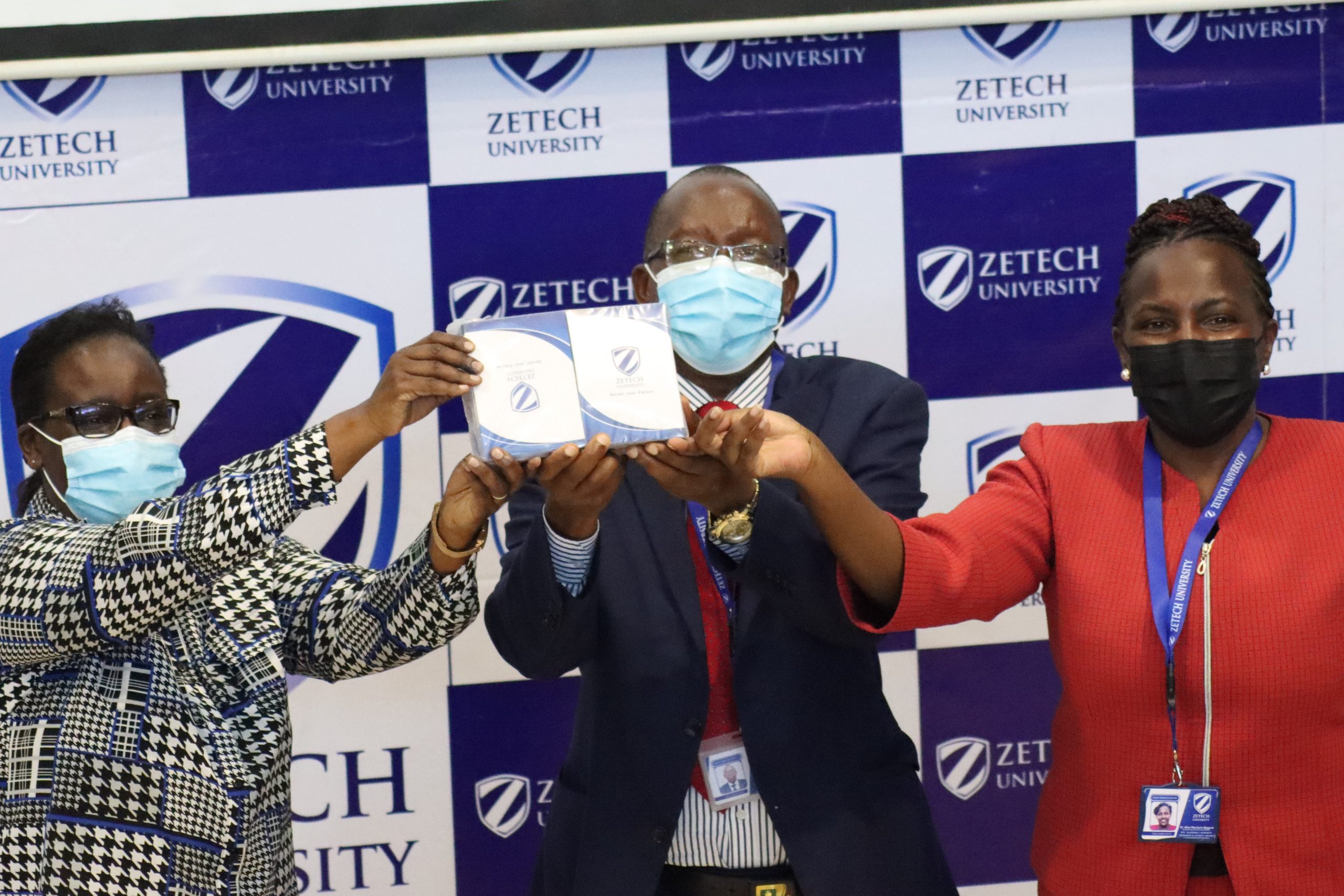The Dean of students Zetech University, Elizabeth Muhia (left) presents the University Service Charter to the Vice-Chancellor Professor Njenga Munene (center) and the Deputy Vice-Chancellor Dr. Alice Njuguna (right) during the Zetech University Service Charter launch at Thika Road Campus.